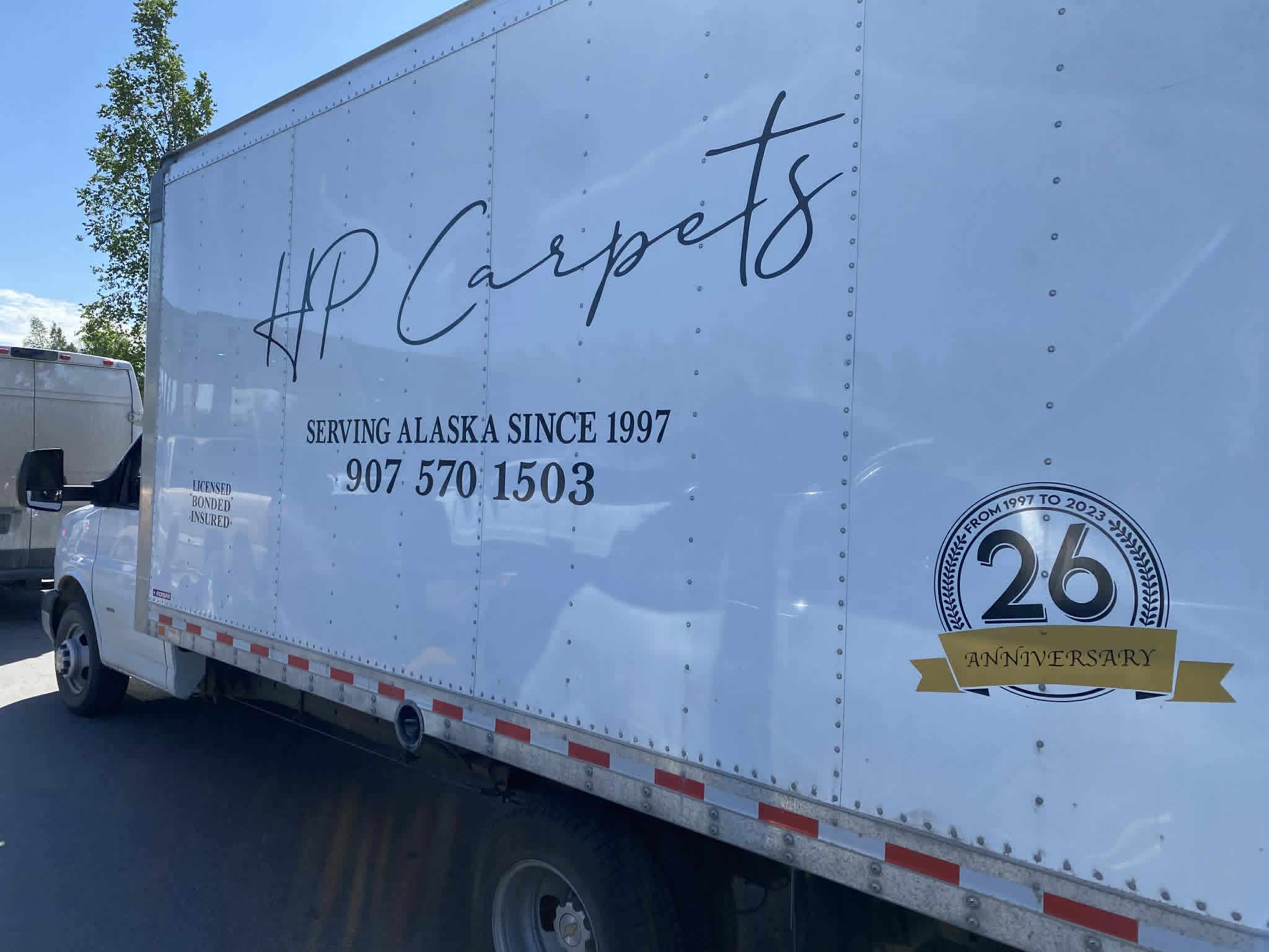 HP Carpets box truck in Anchorage — Serving Alaska since 1997, licensed, bonded and insured, with a 26th anniversary badge